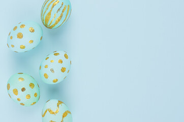 Modern easter background - blue eggs with golden design as border on blue color, copy space.