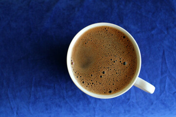cup of coffee on table, top view, blue background, top view