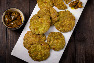 crispy and salty mathri with mango pickle on a white tray