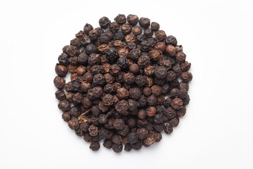 Macro close-up of Organic Black pepper (Piper nigrum) on white background. Pile of Indian Aromatic Spice. Top view