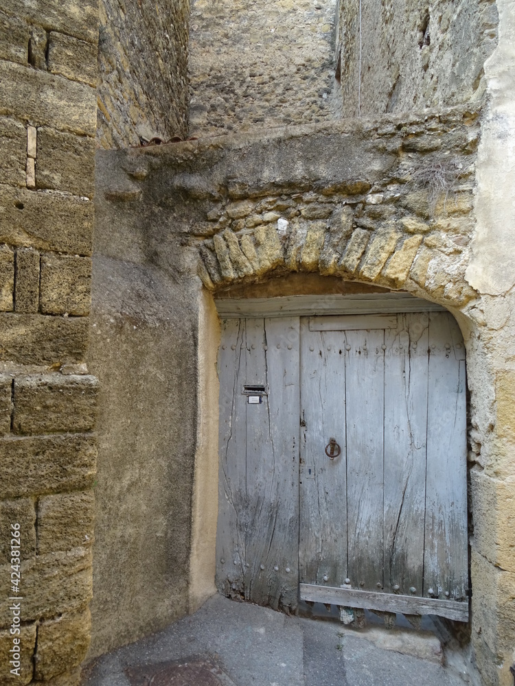 Wall mural old wooden door in wall of a troglodyte cave of a house