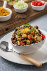 black gram or kala chana chaat with boiled potato, onion, tomato with a dash of lemon juice served on a white bowl