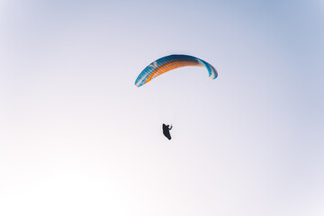 Paragliding at sunset over the mountains, Italy