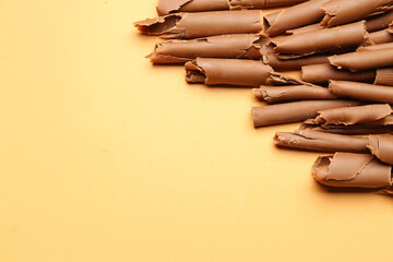 Delicious chocolate curls on color background