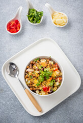 black gram or kala chana chaat with boiled potato, onion, tomato with a dash of lemon juice served on a white bowl