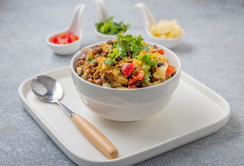 black gram or kala chana chaat with boiled potato, onion, tomato with a dash of lemon juice served on a white bowl