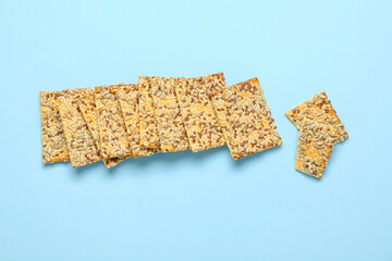 Tasty crackers with seeds on color background