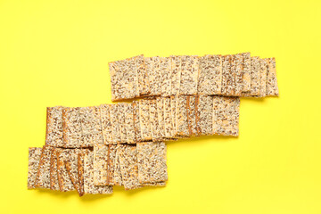 Tasty crackers with seeds on color background