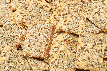 Tasty crackers with seeds as background