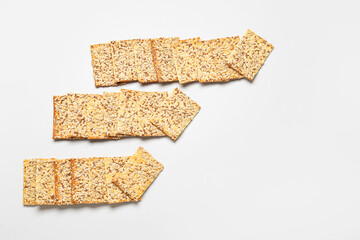 Tasty crackers with seeds on white background