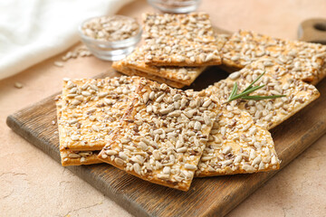 Tasty crackers with seeds on color background