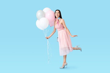 Beautiful young woman with balloons on color background