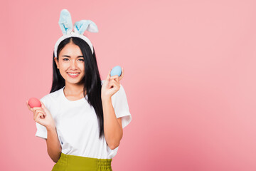 woman smiling wearing rabbit ears holding colorful Easter eggs gift on hands