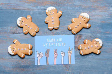 Cookies and greeting card for Friendship Day on color wooden background