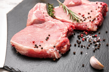 Fresh raw meat and spices on dark background, closeup