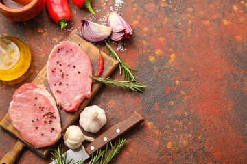 Board with fresh raw meat and spices on grunge background