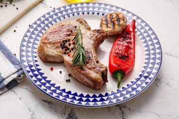 Plate with tasty steak and spices on light background