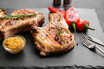 Tasty steaks with spices on dark background