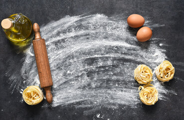 Flour and rolling pin on the table. The process of cooking tagliatelle pasta on the kitchen table.