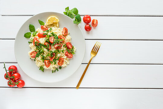 Fresh home-made tabouli, or tabbouleh salad, top view on white wooden background with copy space