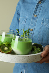 Woman hold tray with glasses of smoothie and ingredients