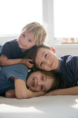 Obraz premium Three beautiful children, boy brothers, having family portrait, hugging
