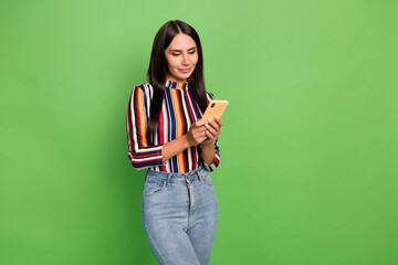 Portrait of attractive focused girl using device gadget app 5g browsing isolated over bright green color background