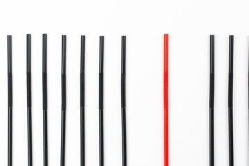 Concept about difference, many black straws and red one 