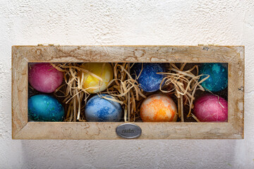 Easter eggs in a box with straw.