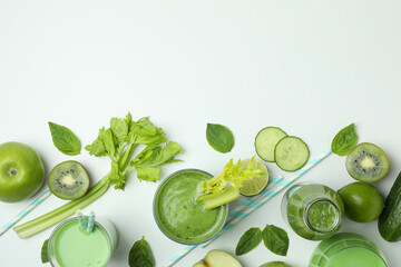 Glasses of green smoothie and ingredients on white background, top view