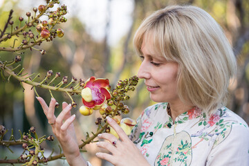 Portrait of a young blonde girl with exotic flowers of Asian cannonball tree