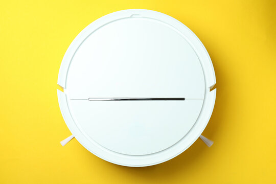 Robot Vacuum Cleaner On Yellow Background, Top View