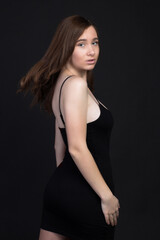 Young brown-haired woman, studio photo on black background