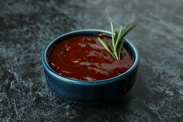 Bowl of barbecue sauce on black smoky background