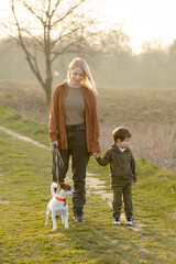 Fototapeta premium mother and son are walking along the countryside road at sunset