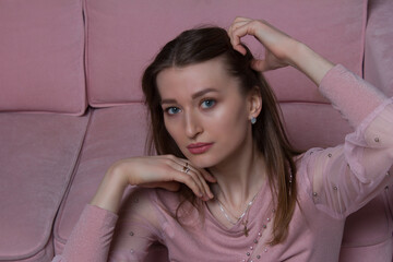Naklejka premium Studio portrait of a young woman with brown and long hair in pink clothes and underwear