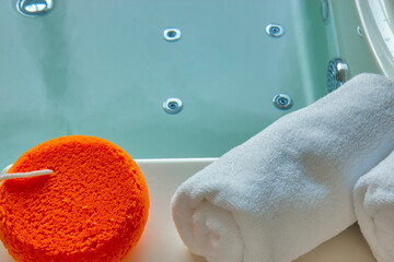 Orange sponge and towel on the hot tub