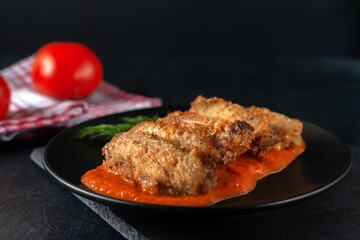Buffolo wings close-up in ceramic bowl with tomato sauce and tomatoes
