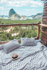 hat against Phang Nga bay background, Tourists relaxing in tropical resort at Samet Nang She, near Phuket in Southern Thailand. Southeast Asia travel and summer vacation, freelance concept - obrazy, fototapety, plakaty