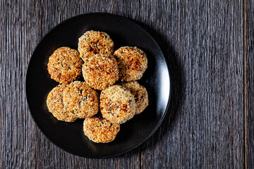 sesame lamb patties on a black plate