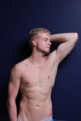 Naklejka premium A young and masculine guy poses in the torso.