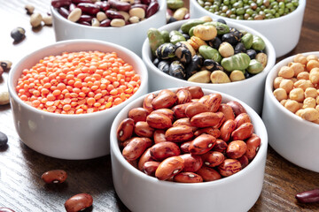 Legumes assortment in bowls on a wooden table