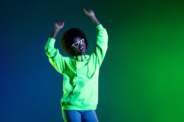 Photo of funny pretty dark skin lady raise hands dancing have good mood isolated on vivid color background