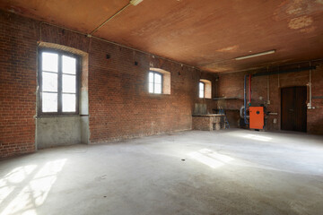 Old workshop interior with brick walls and windows, sunlight