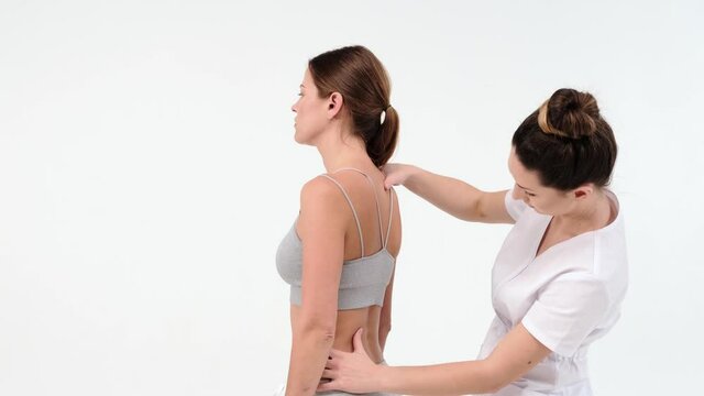 Chiropractor or Physical Therapist session on white background - doctor massaging his woman client back