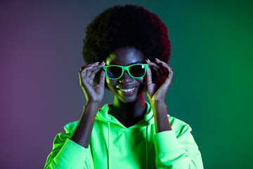 Photo of charming confident clubber lady wear vintage sunglass hoodie isolated gradient green neon background