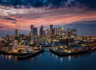 Fototapeta na wymiar Aerial, panoramic view to the modern skyline of the financial district Canary Wharf in London, United Kingdom, with the illuminated skyscrapers just after sunset
