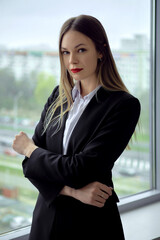 Beautiful business lady standing thoughtfully by the window