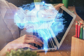 Double exposure of woman hands working on computer and brain hologram drawing. Ai concept.