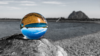 Obraz premium Crystal ball alpine landscape shot with black and white background outside the sphere and details of a rock at Wildkogel Arena, Neukirchen, Salzburg, Austria